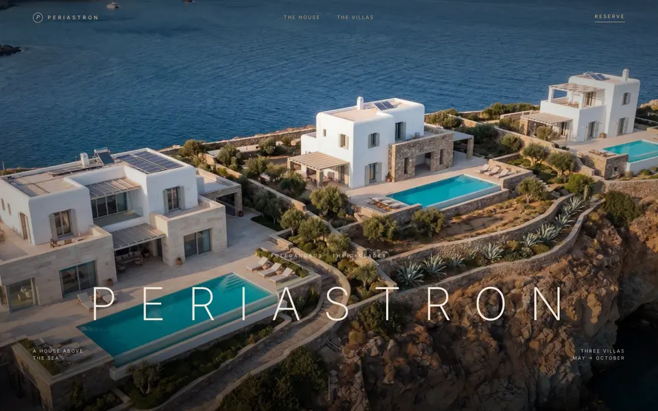 The Periastron home page: aerial photo of three white villas with pools above the sea